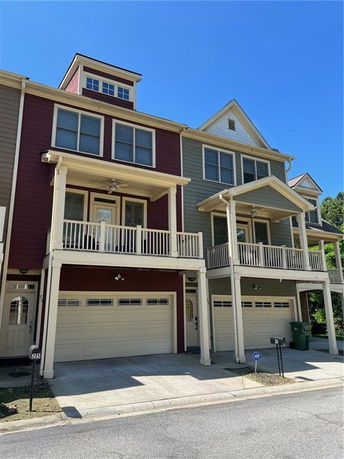 Front view of a multi-level townhouse with a two-car garage and a balcony.