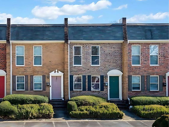 Front view of a row of two-story townhouses with brick exteriors.