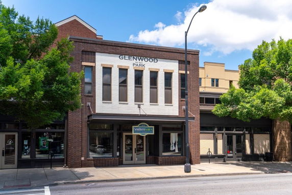 Front view of a multi-story commercial building with a brick facade and large windows.