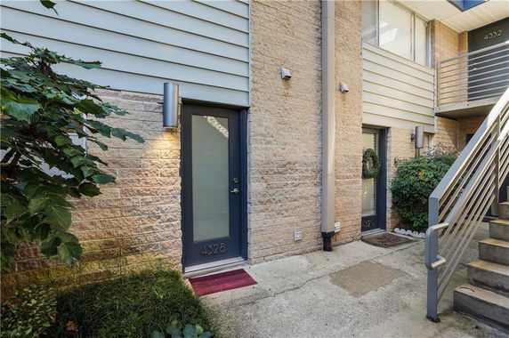 Entryway of a residential building with two doors and adjacent outdoor staircase.