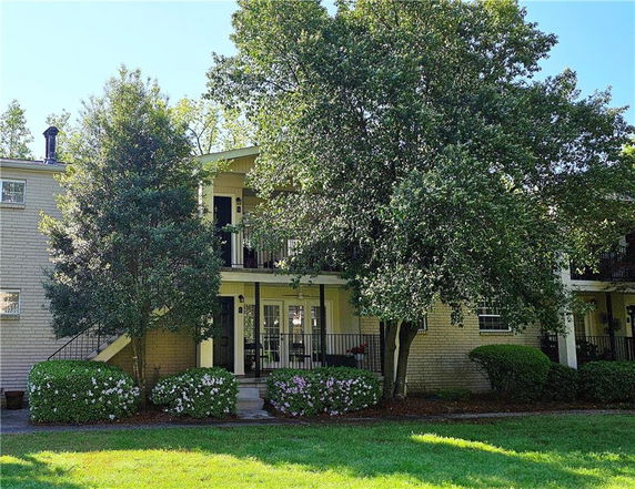 Front view of a two-story building with balconies and exterior stairs.
