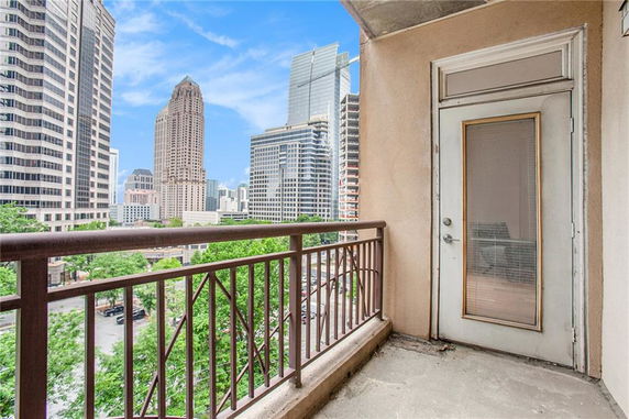 View from a balcony overlooking a cityscape with tall buildings.
