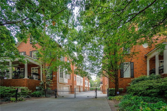 Front view of brick residential buildings with a gated driveway.