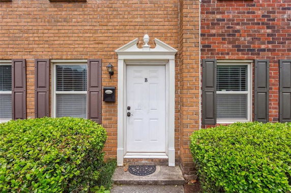 Front view of a house entrance with a white door and brick exterior.