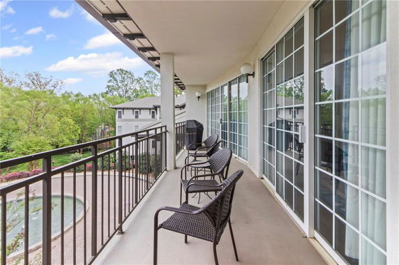 Balcony view with chairs overlooking a courtyard and nearby buildings.