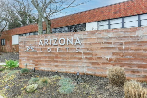 Front view of a building with a brick exterior and a sign labeled 'Arizona Lofts'.
