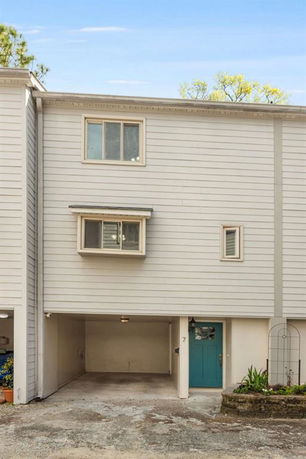 Front view of a multi-story house with a garage and blue front door.
