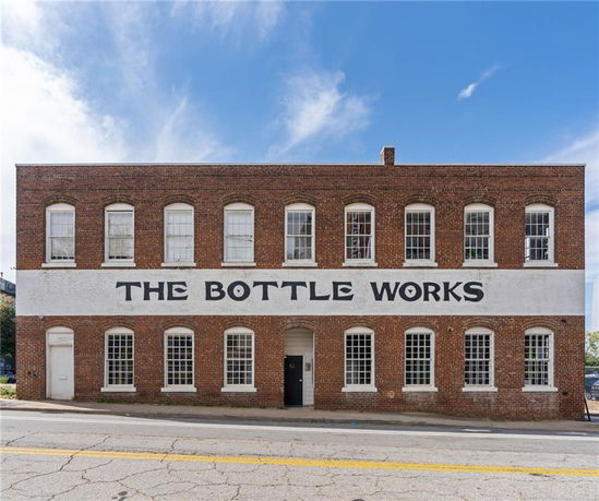 Front view of a two-story brick building with 'The Bottle Works' written on the facade.