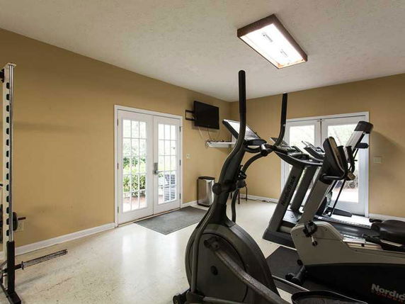 Room with exercise equipment including treadmills and a stationary bike.