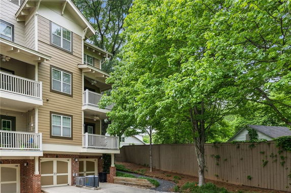 Side view of a multi-story residential building with wooden exterior and balconies.