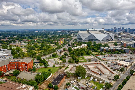 Wide angle view of a cityscape with a large stadium and urban buildings.