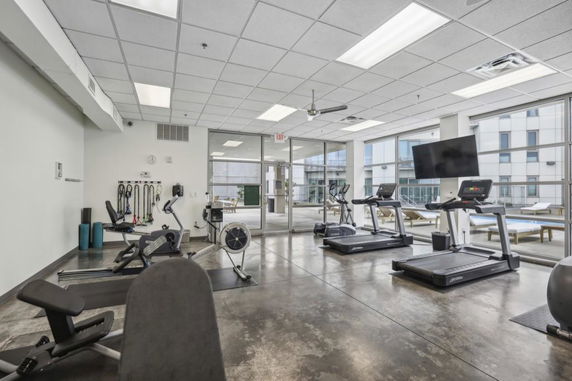 Indoor gym area with exercise equipment and large windows.