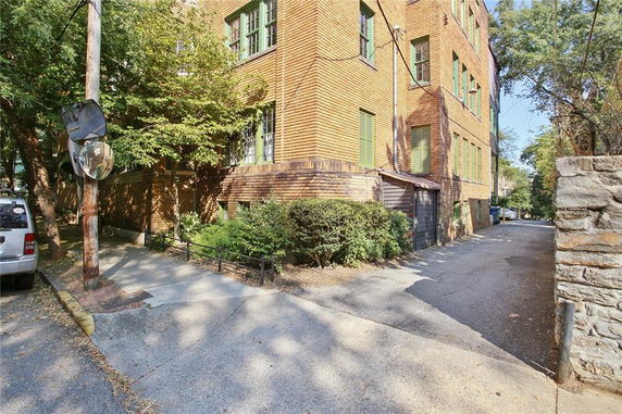 Front view of a multi-story brick building with green window frames.