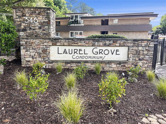 Front view of a condominium building with stone sign displaying 'Laurel Grove Condominiums'.