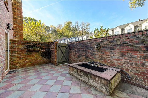 Outdoor patio area with brick walls and a small fountain.