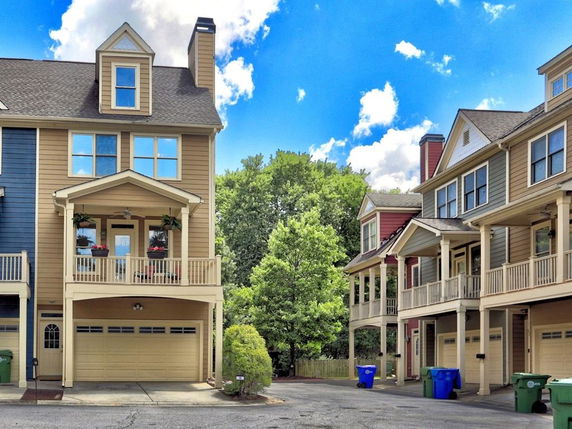 Front view of townhouses with garages and balconies.