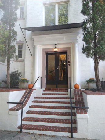 Front view of a building with brick steps and white columns at the entrance.