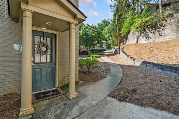 Front view of a building entrance with a blue door and two columns.