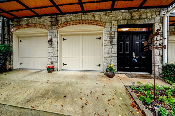 Front view of a house with a double garage and stone facade.