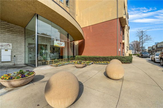 Front view of a building with glass entrance and decorative stone balls.