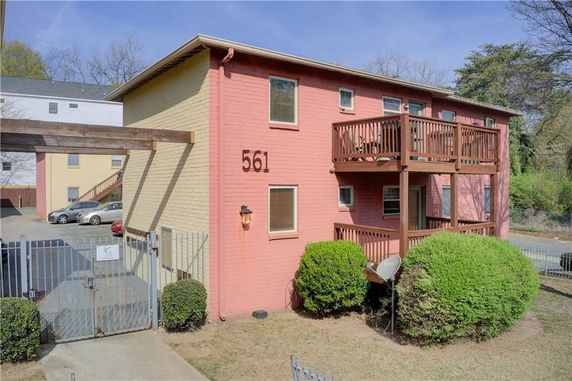 Front view of a two-story building with balconies and a gated entrance.
