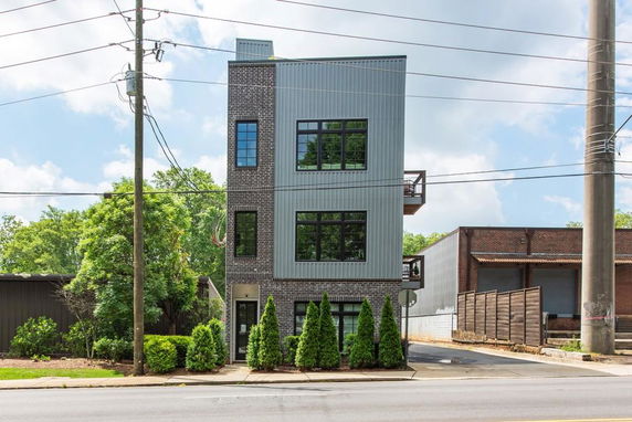 Front view of a modern three-story building with a mix of brick and metal exterior.