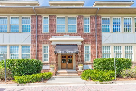 Front view of a two-story brick building with large windows and an awning over the entrance.