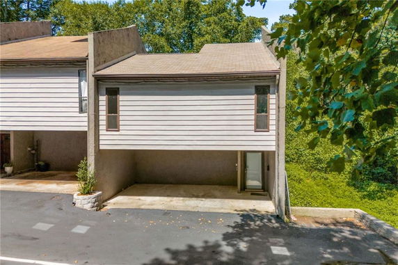 Front view of a two-story house with an overhang and driveway.
