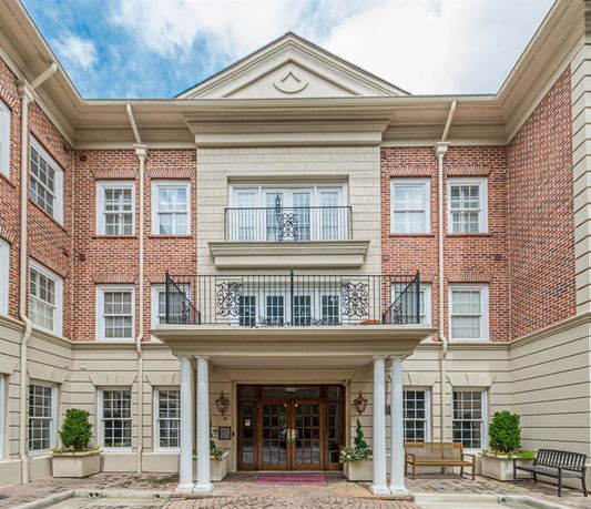 Front view of a multi-story brick building with a symmetrical design and a central entrance.