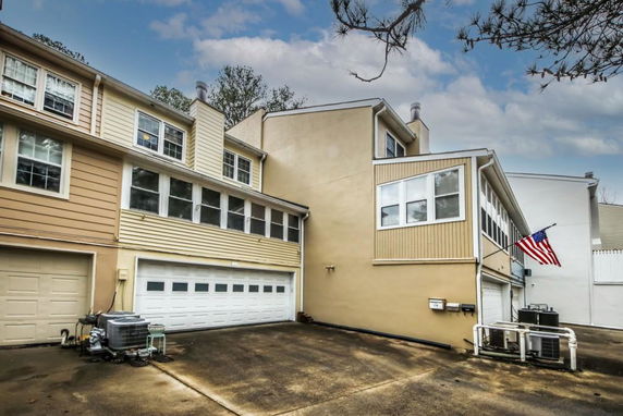 Front view of a multi-story house with double garage and multiple windows.