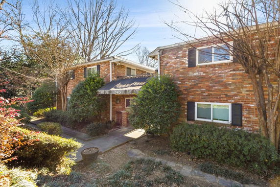 Front view of a two-story brick house with a small entrance awning.