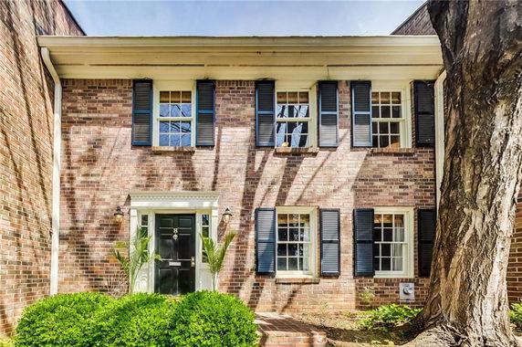 Front view of a two-story brick house with multiple windows and a central entrance.