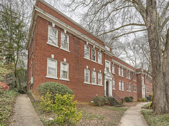Front view of a two-story brick building with white window trim.