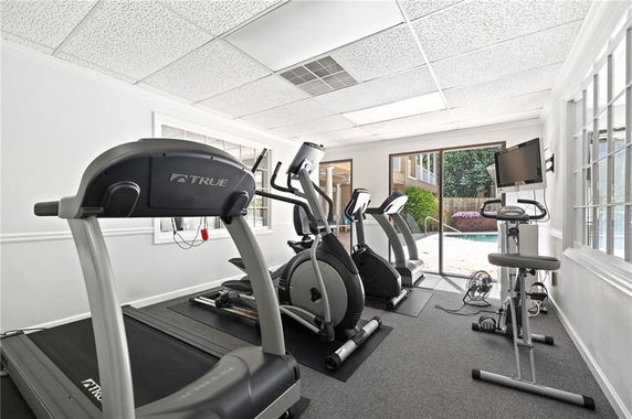 Indoor gym area with exercise equipment including treadmills and an exercise bike.