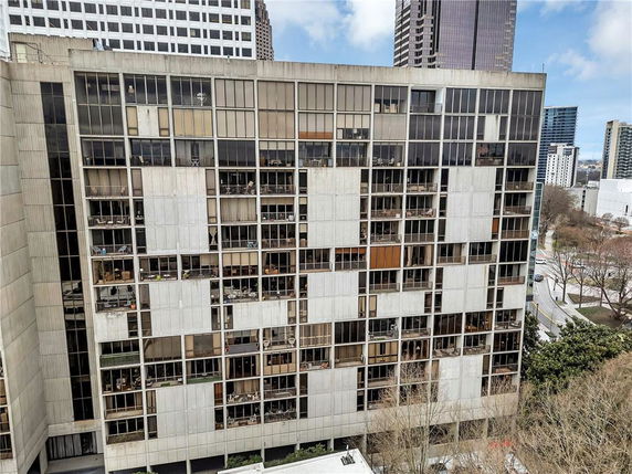 Front view of a multi-story building with numerous windows and balconies.