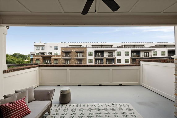 View from a patio overlooking a row of modern apartment buildings.