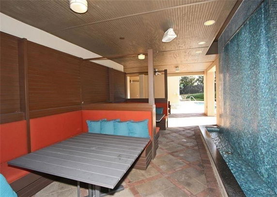 Indoor seating area with benches and a water feature in a recreational space.