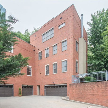 Front view of a multi-story brick building with multiple garage doors.