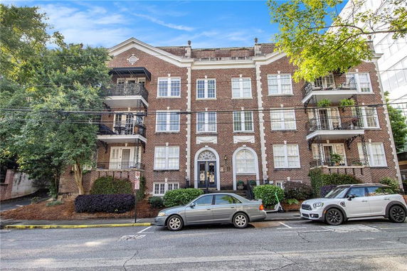 Front view of a multi-story brick building with balconies.