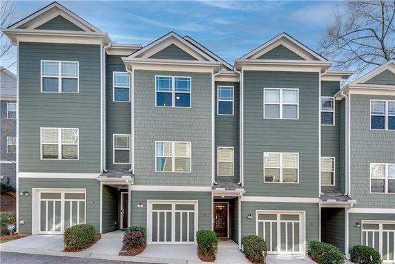 Front view of a townhouse complex with multiple levels and green siding.