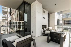 View from a modern balcony with glass railings and outdoor seating area.