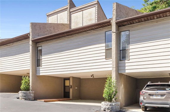 Front view of a building with a driveway and carport area.