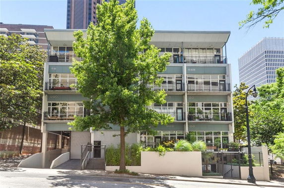 Front view of a multi-story building with balconies and large windows.