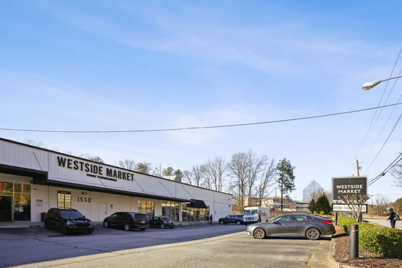 Front view of a single-story commercial building with a parking area in front.