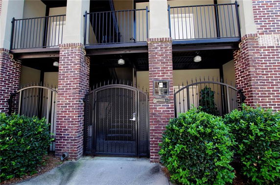 Front view of a two-story structure with brick facade and metal gates.