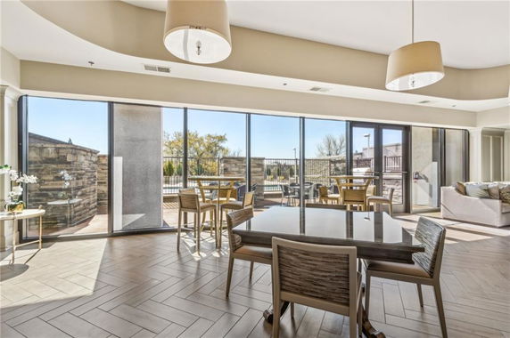 Interior view of a recreational space with large windows, tables, and chairs.