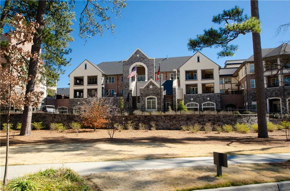 Front view of a large residential building with stone and stucco facade.