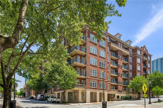Front view of a multi-story brick building with balconies.