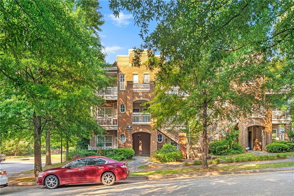 Front view of a multi-story brick building with balconies.