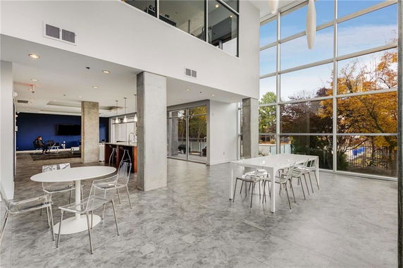 Spacious modern indoor area with large windows and seating arrangement.